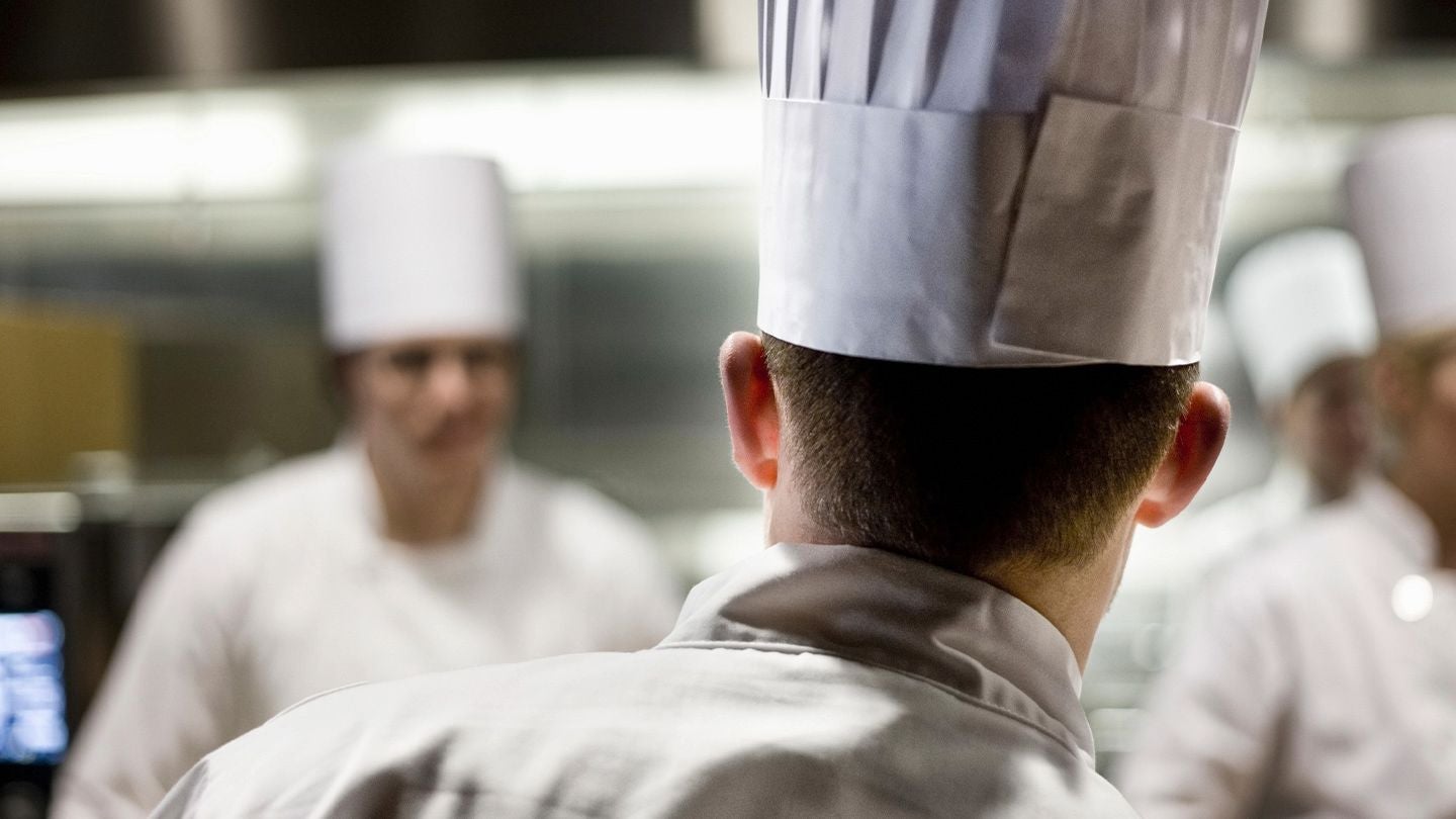 Chef de cocina liderando al equipo durante el servicio en una cocina profesional