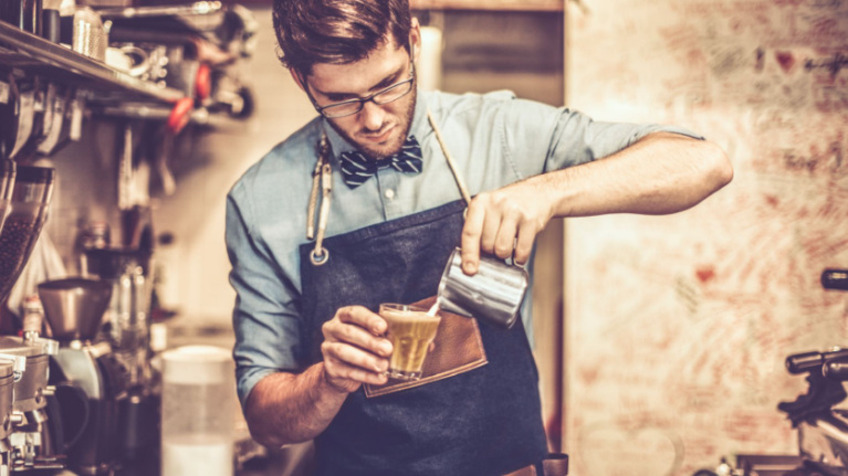 Joven barista preparando un café