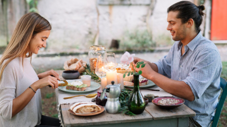 Pareja disfrutando de una cena romántica en un restaurante al aire libre