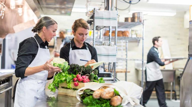 Dos chefs manipulan alimentos para verificar si son frescos, inocuos y de calidad