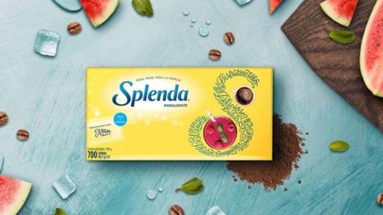 Caja de sobres de endulzante Splenda rodeada de rodajas de sandía, granos de café y hojas de menta