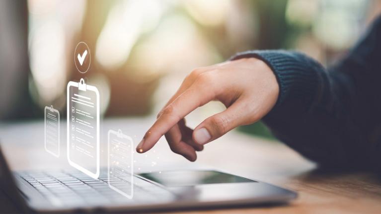 Mano revisa checklist digital en laptop como parte del control de calidad de alimentos.