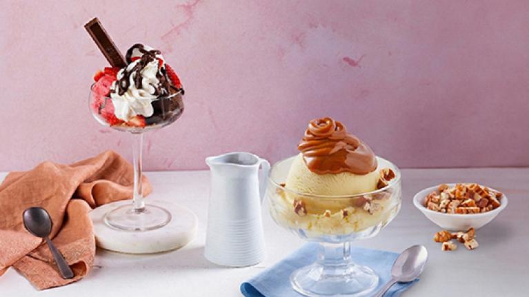 Vasos de helado con frutas, crema, chocolate y caramelo como opciones de toppings para helados