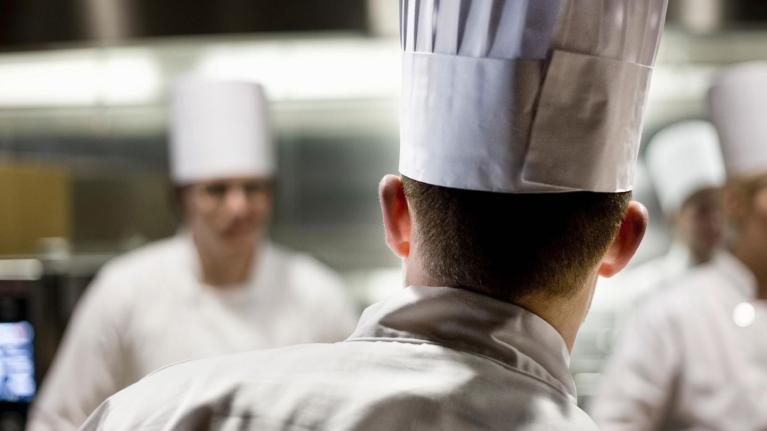 Chef de cocina liderando al equipo durante el servicio en una cocina profesional