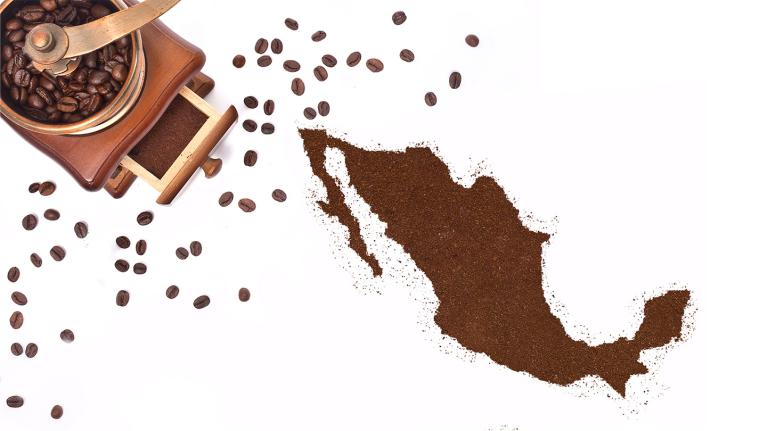 Mapa de México formado con café molido junto a molino y granos tostados dispersos