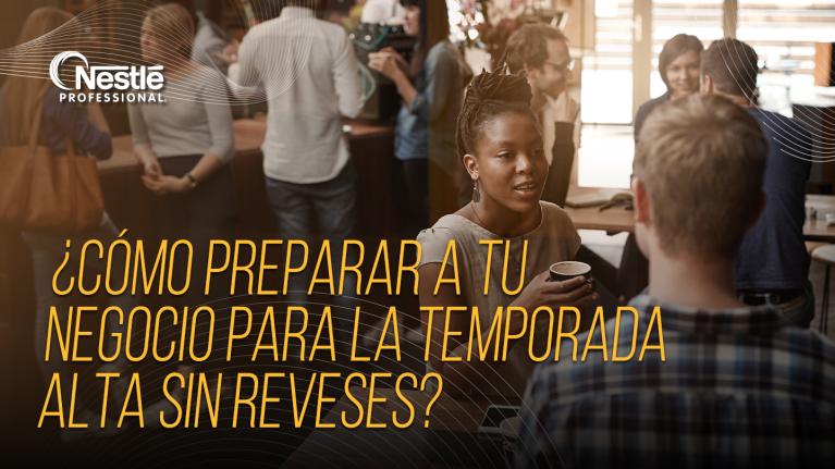 Clientes conversan animadamente en la mesa de un restaurante concurrido durante un evento.