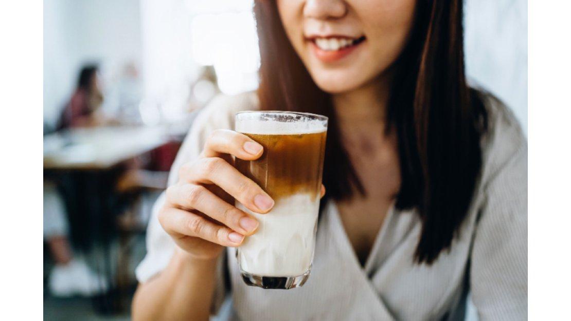 Mujer tomando una bebida de café hecha por baristas