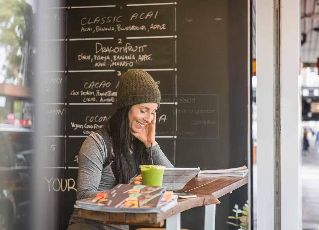 Cliente feliz revisa el menú de restaurante digitalizado en una Tablet