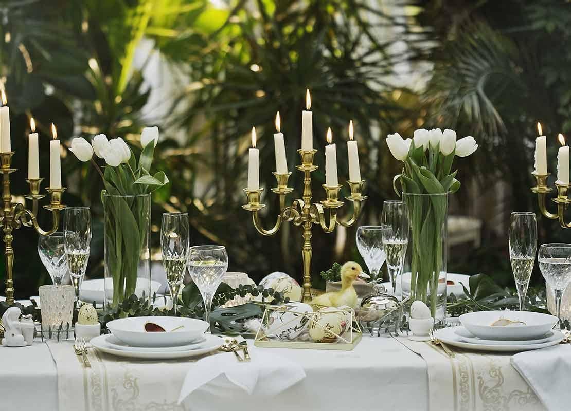 Velas, cubiertos y flores en un comedor de un restaurante temático que transmite frescura y conecta con la naturaleza