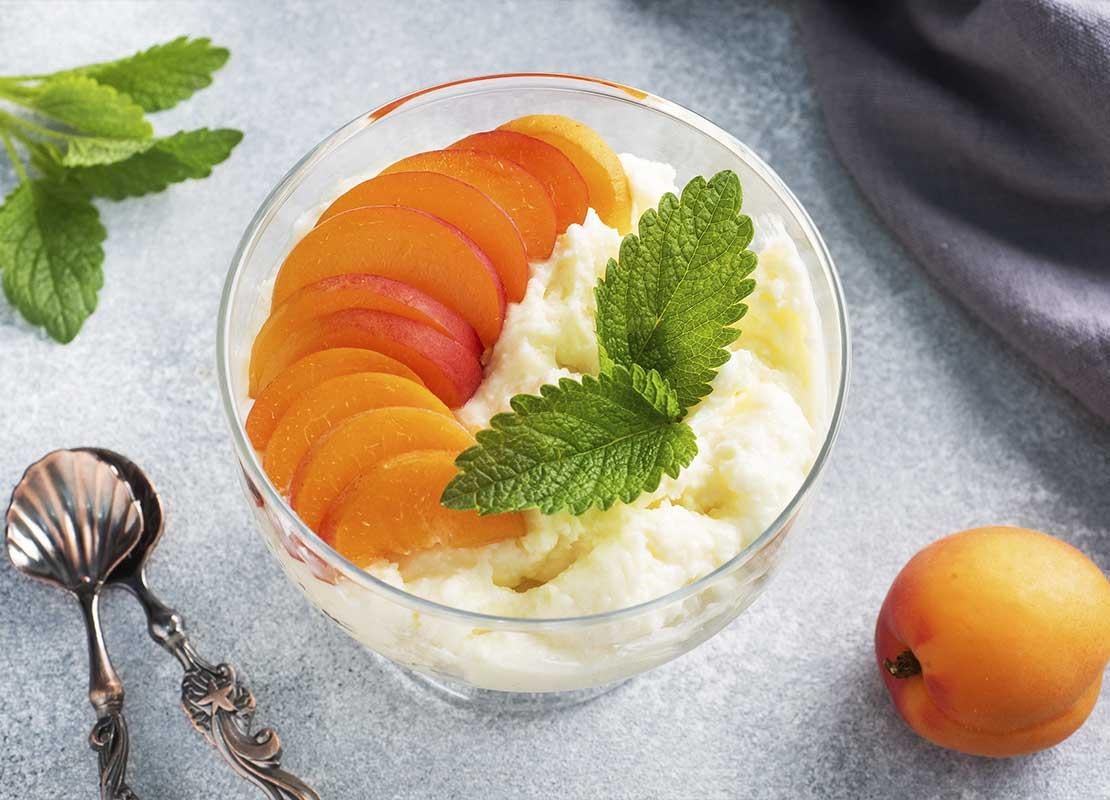 Una preparación de helado, duraznos y hierbabuena que hace parte de un menú de postres