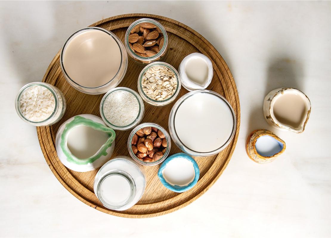 Bebidas vegetales de coco, avena, avellanas, almendras y arroz y recipientes con estos ingredientes