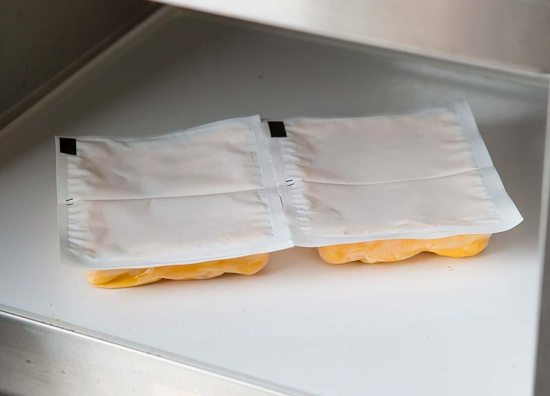 2 paquetes de queso sellados al vacío dentro de una máquina envasadora