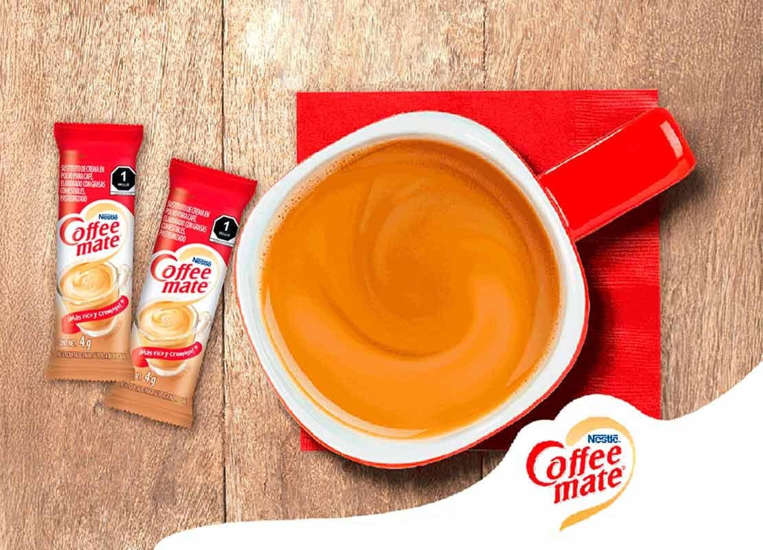 Taza roja de café elaborada con NESCAFÉ y COFFEE MATE®, al lado, sticks de los sustitutos de crema