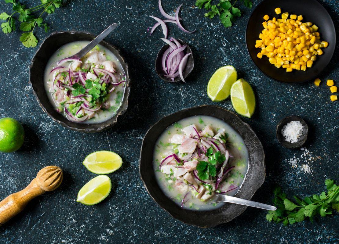 Dos bowls con pescado, cebolla morada y hierbas acompañados de limón