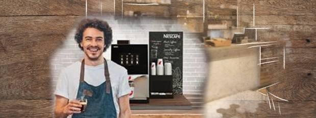 Barista sonriente frente a cafeteras NESCAFÉ® e insumos.