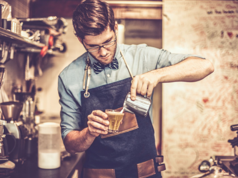 Joven barista preparando un café