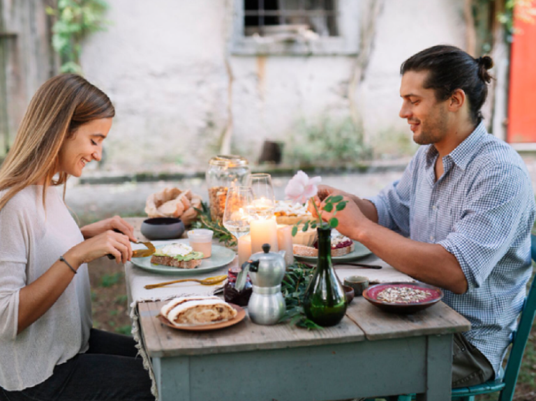 Pareja disfrutando de una cena romántica en un restaurante al aire libre