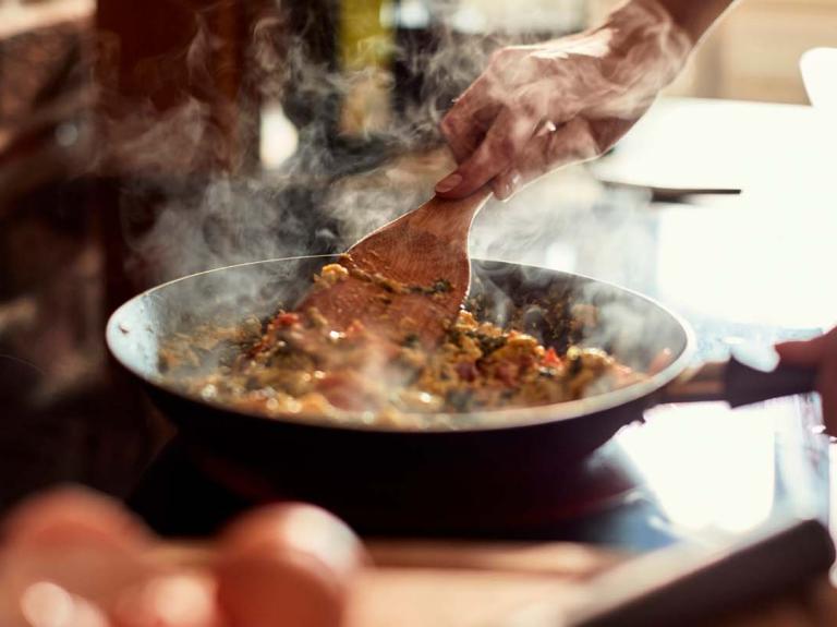 Hombre preparando un plato con un tipo de cocción específico