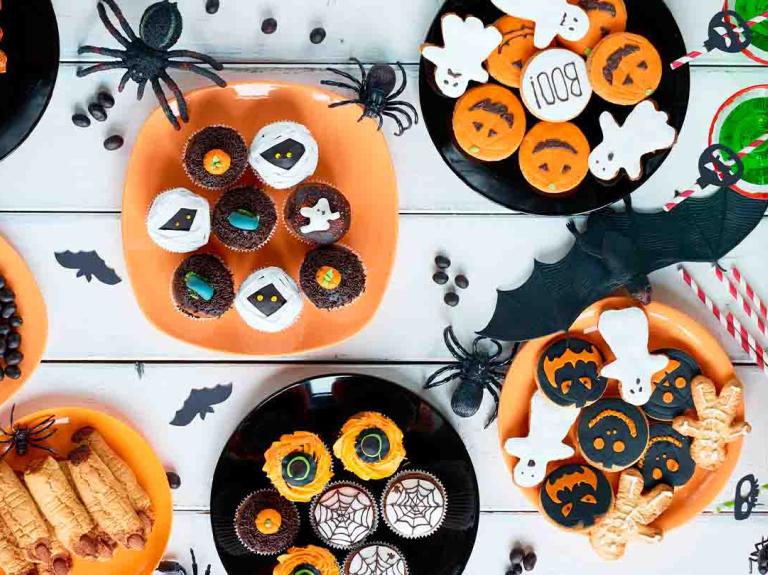 Vista en ángulo alto de varios postres decoradas para una fiesta de Halloween acordes con la temática