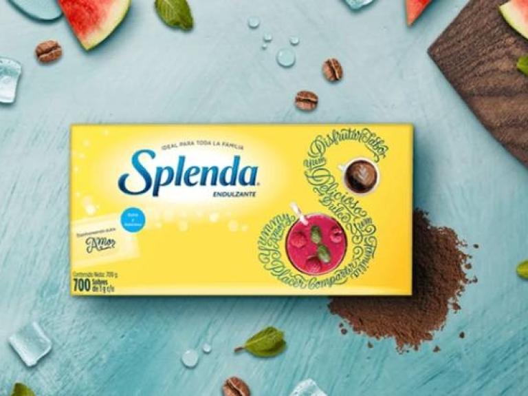 Caja de sobres de endulzante Splenda rodeada de rodajas de sandía, granos de café y hojas de menta