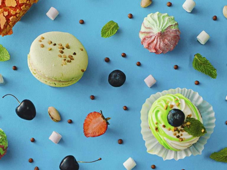 Vista superior de macaron, cupcake y merengues de colores