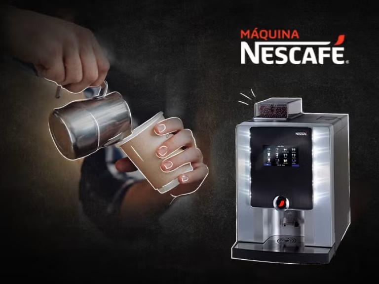 Una persona vierte leche en una taza de café junto a una elegante cafetera NESCAFÉ® sobre un fondo oscuro.