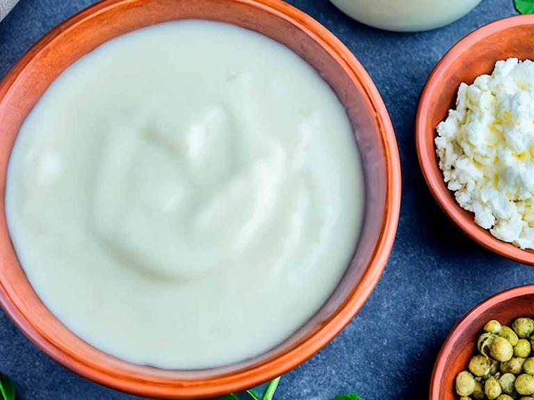 Cuencos con guisantes secos, yogur, requesón y una botella de bebida vegetal como sustitutos de la leche