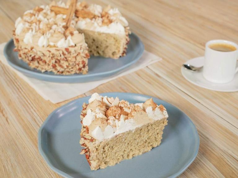 Pastel vegano decorado con crema vegetal, merengue y canela, acompañado de un café espresso