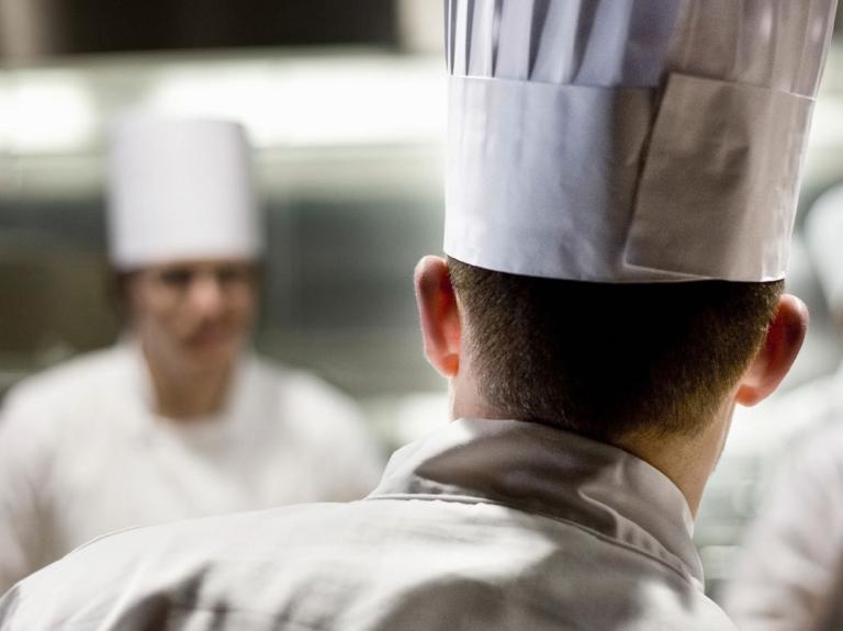 Chef de cocina liderando al equipo durante el servicio en una cocina profesional