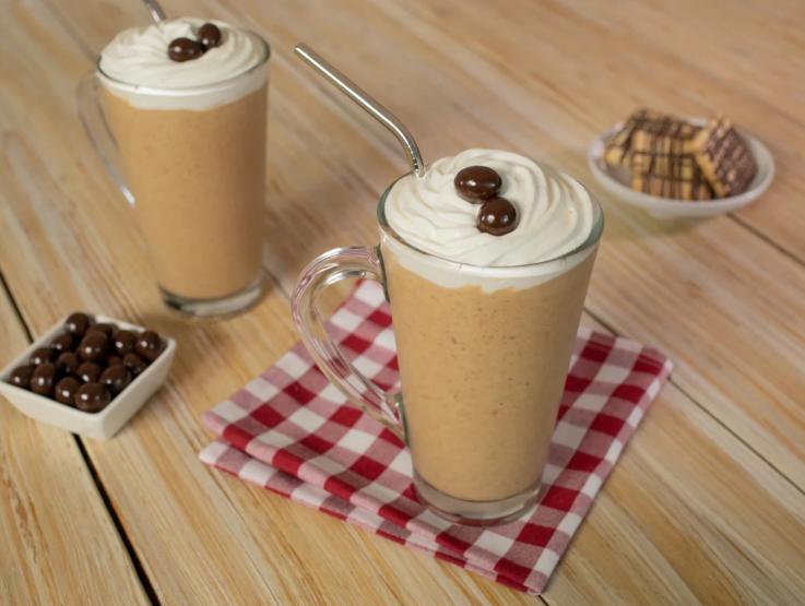 Dos vasos de cappuccino elaborados con COFFE MATE® para foodservice, decorados con crema batida