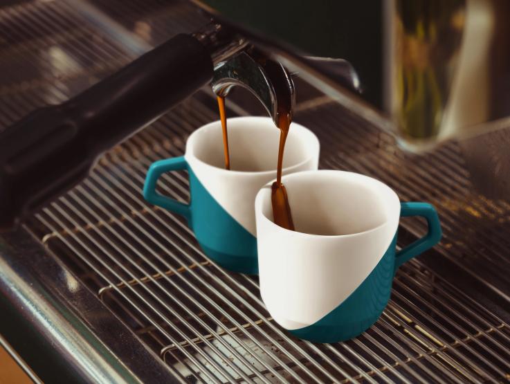 Dos tazas de café siendo llenadas con café espresso premium ROASTELIER™