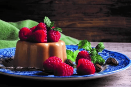 Gelatina de café con topping de frambuesas servida sobre plato azul
