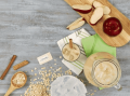 Jarra y vaso con bebida de avena y canela junto a una manzana entera y en trozos y un sobre de Splenda
