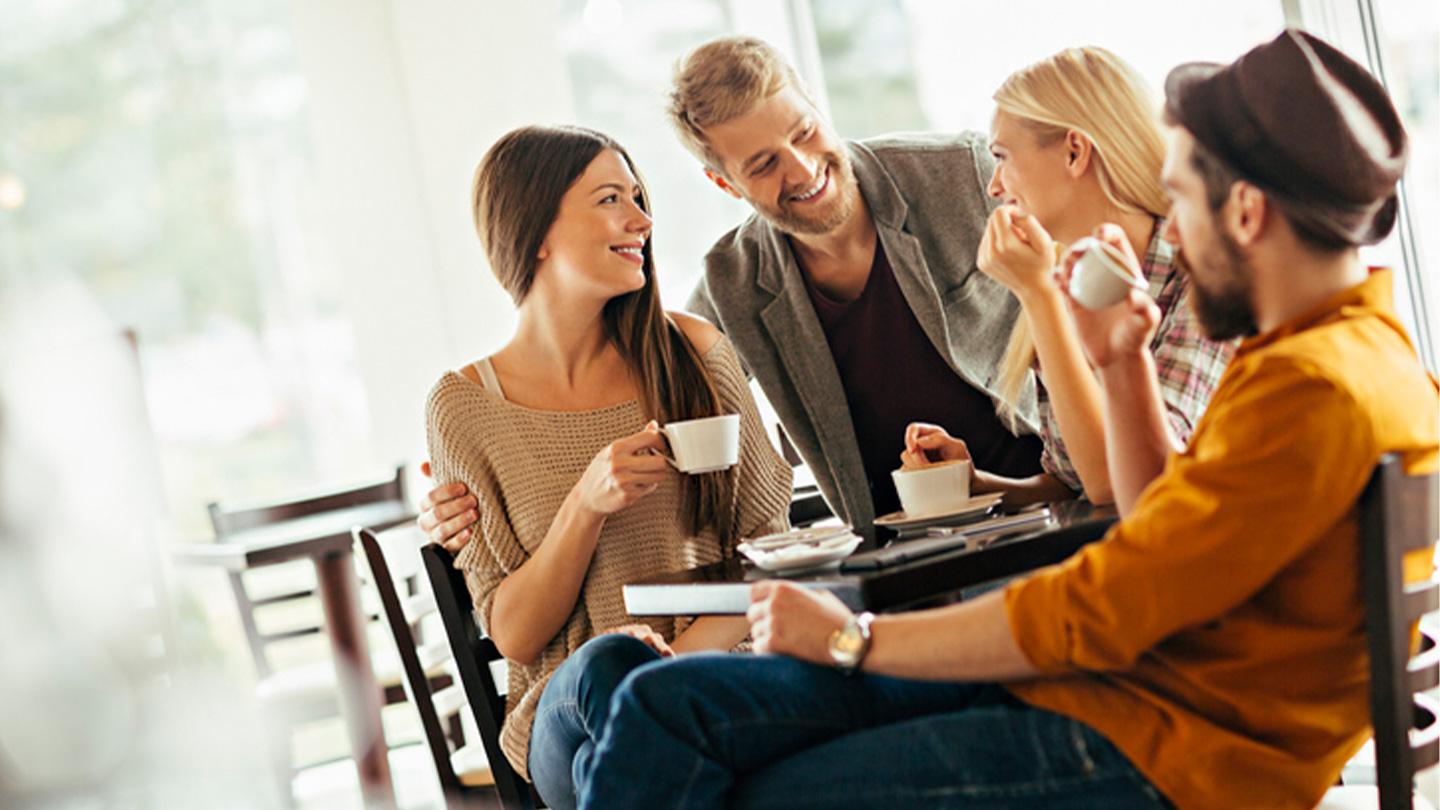 Una pareja feliz comparte un brunch con NESCAFÉ® en una cafetería