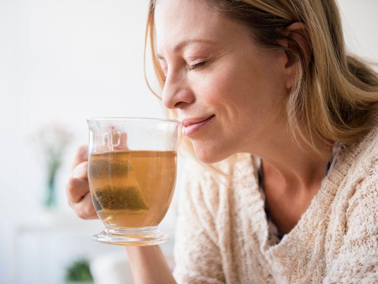Mujer disfrutando una infusión caliente en un ambiente luminoso y relajado