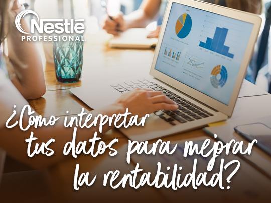Persona analizando gráficos de barras y sectores en una computadora portátil sobre un escritorio.