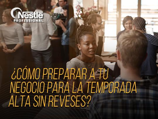 Grupo de personas reunidas conversando dentro de una cafetería durante una jornada concurrida.